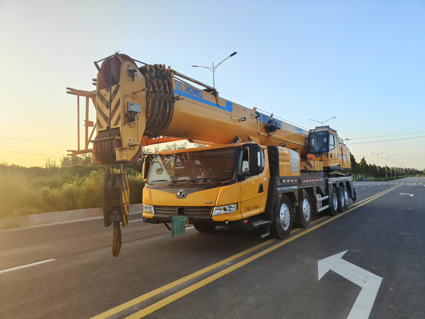 How does the cost of a used boom crane compare to a new one?